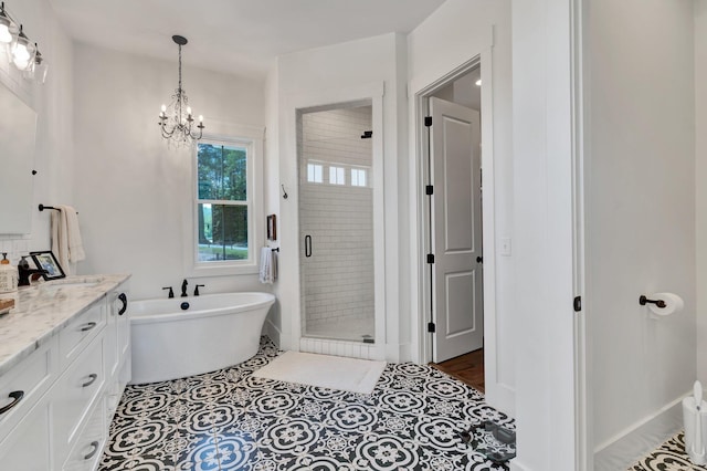 bathroom featuring tile patterned floors, vanity, shower with separate bathtub, and a chandelier