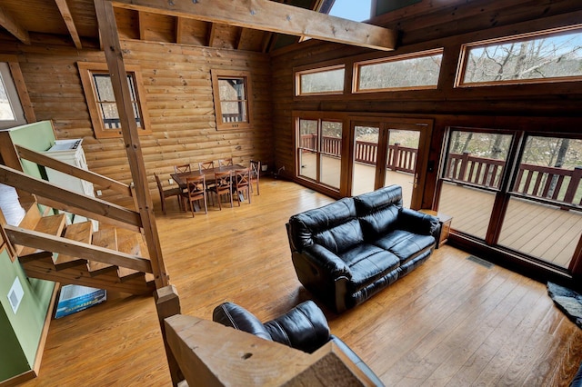 living room with hardwood / wood-style flooring, wood ceiling, beam ceiling, and log walls