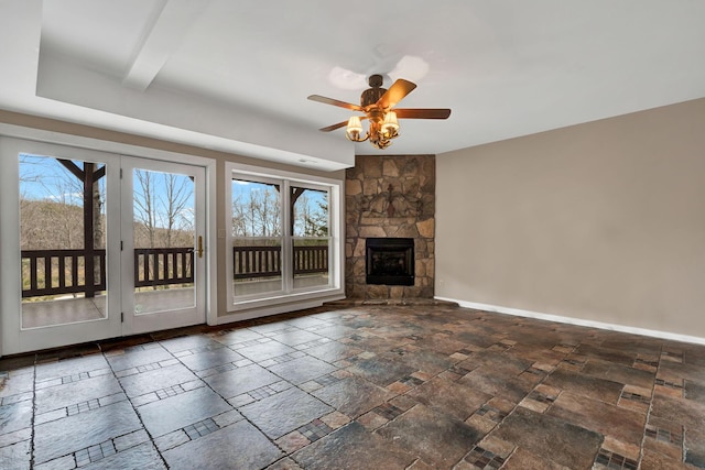 unfurnished living room featuring ceiling fan and a fireplace