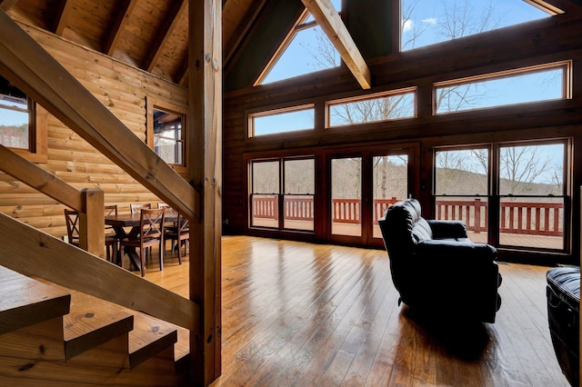 living room with high vaulted ceiling, hardwood / wood-style floors, wooden ceiling, and beam ceiling