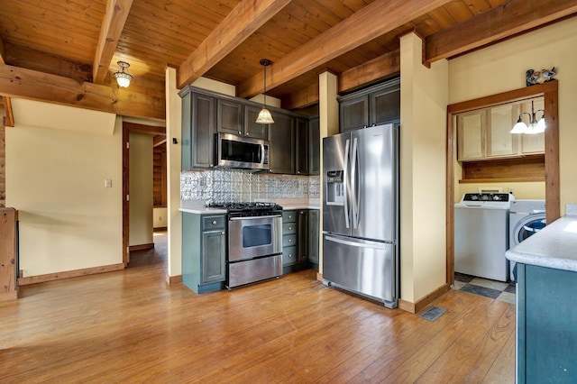 kitchen with pendant lighting, appliances with stainless steel finishes, beam ceiling, washer / clothes dryer, and wooden ceiling