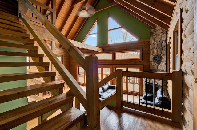 staircase featuring hardwood / wood-style flooring, high vaulted ceiling, wood ceiling, and beam ceiling