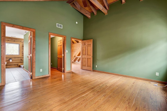 unfurnished bedroom with beamed ceiling, wood ceiling, high vaulted ceiling, and light wood-type flooring