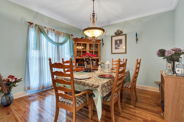 dining space featuring crown molding and light wood-type flooring