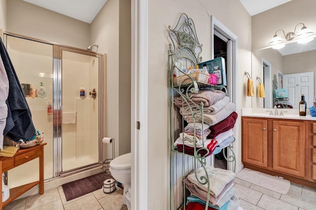 bathroom with tile patterned flooring, vanity, a shower with door, and toilet