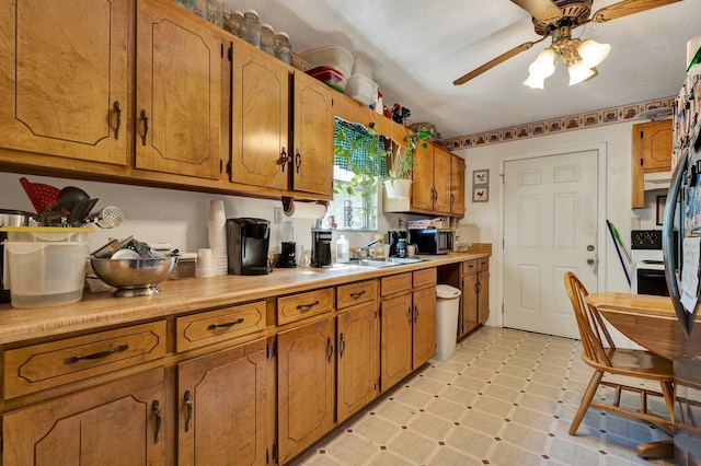 kitchen with electric stove, ceiling fan, and sink