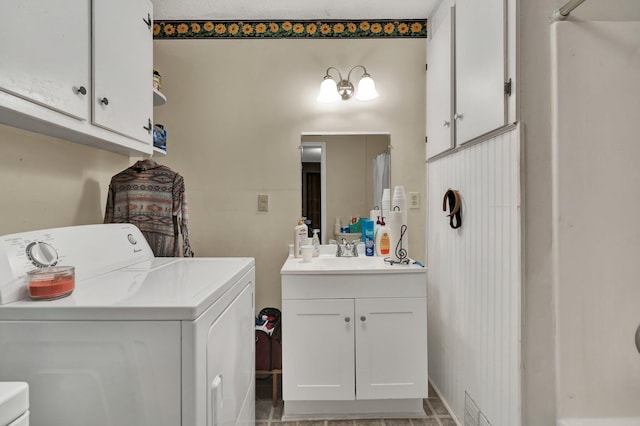 washroom with sink, washer and clothes dryer, and cabinets