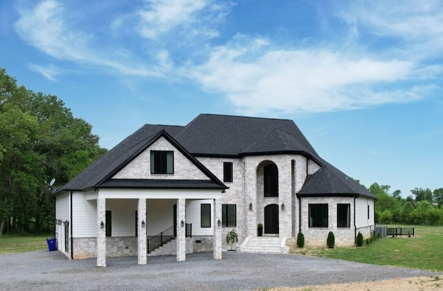 view of front of house with a front yard and central AC unit