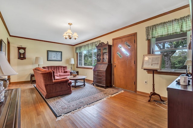 living room featuring crown molding, a chandelier, and light wood-type flooring