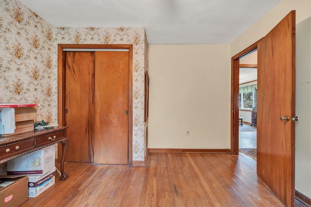 unfurnished bedroom with a closet and light wood-type flooring