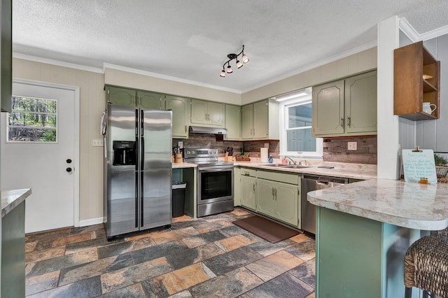 kitchen with green cabinetry, sink, kitchen peninsula, stainless steel appliances, and a textured ceiling