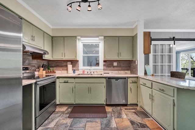 kitchen featuring stainless steel appliances, sink, green cabinets, and kitchen peninsula