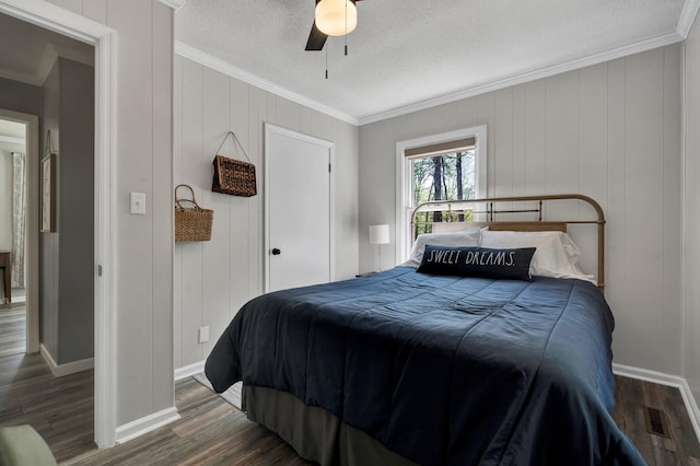 bedroom featuring dark hardwood / wood-style flooring, a textured ceiling, crown molding, and ceiling fan