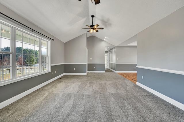 carpeted empty room with lofted ceiling, a textured ceiling, and ceiling fan