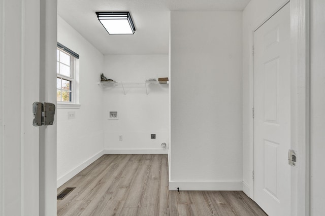 washroom with hookup for a washing machine and light hardwood / wood-style flooring