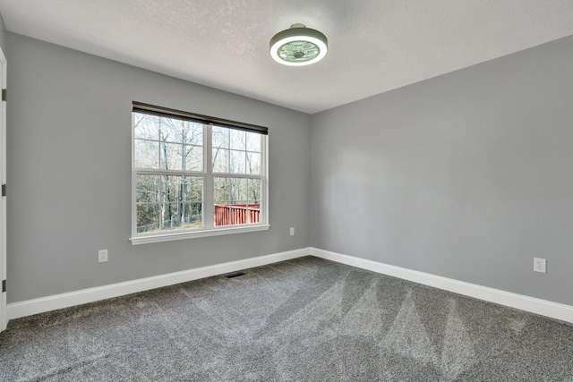 unfurnished room featuring carpet flooring and a textured ceiling