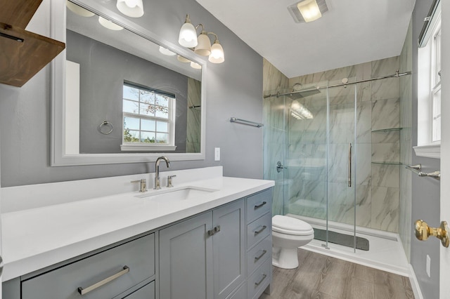 bathroom with vanity, toilet, hardwood / wood-style floors, and walk in shower