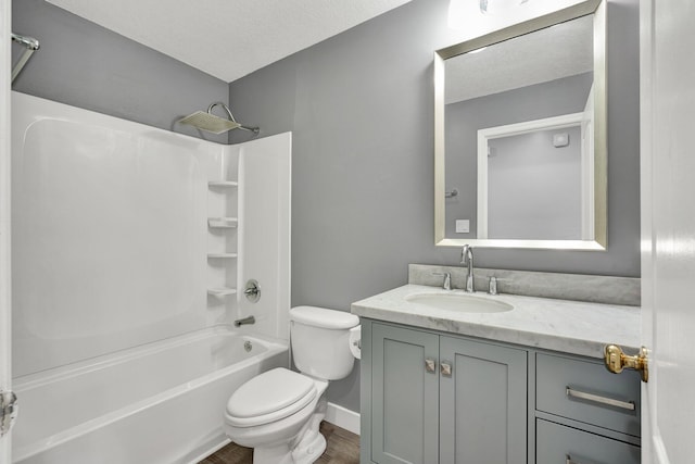 full bathroom with vanity, tub / shower combination, a textured ceiling, and toilet