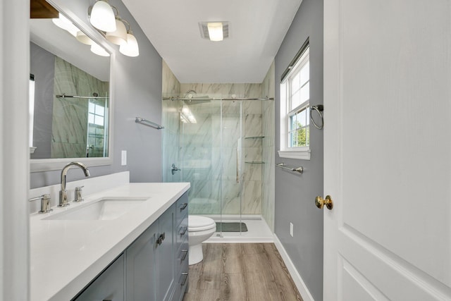 bathroom featuring hardwood / wood-style flooring, vanity, toilet, and an enclosed shower