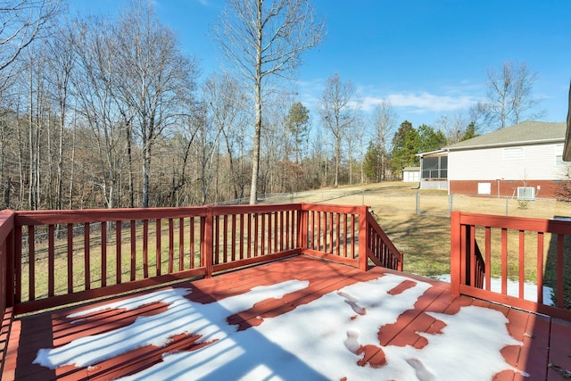 deck featuring a sunroom and a lawn