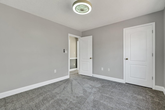 unfurnished bedroom with dark carpet