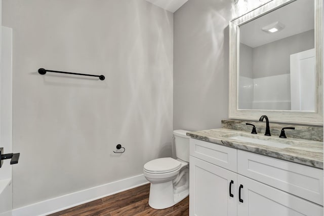 bathroom featuring vanity, wood-type flooring, and toilet