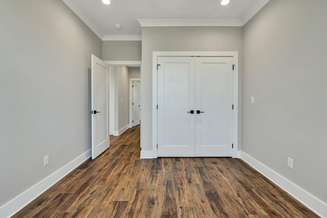 unfurnished bedroom featuring a closet, ornamental molding, and dark hardwood / wood-style floors