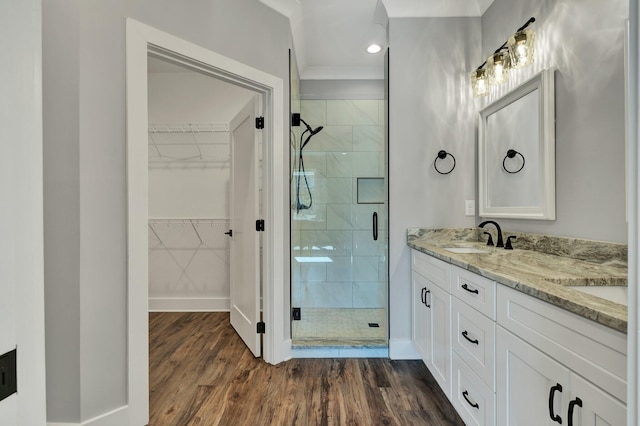 bathroom featuring an enclosed shower, vanity, and wood-type flooring