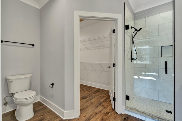 bathroom with wood-type flooring, an enclosed shower, and toilet