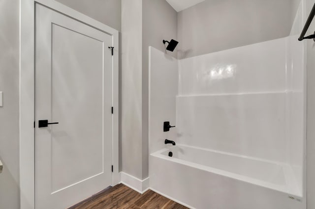 bathroom with hardwood / wood-style flooring and shower / washtub combination