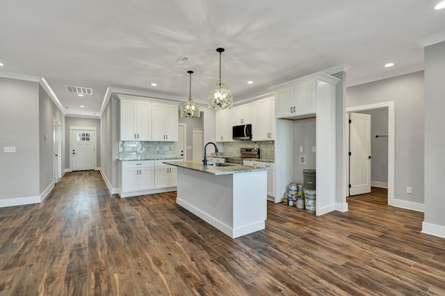 kitchen featuring stainless steel appliances, pendant lighting, a center island with sink, and white cabinets