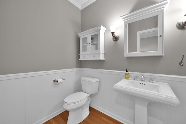 bathroom with hardwood / wood-style floors, crown molding, sink, and toilet