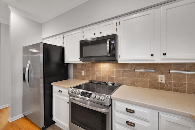 kitchen featuring white cabinetry, decorative backsplash, stainless steel appliances, crown molding, and light wood-type flooring