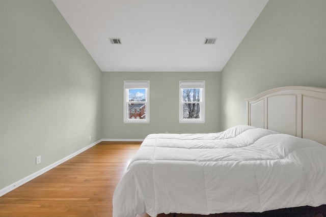 bedroom featuring lofted ceiling and light wood-type flooring