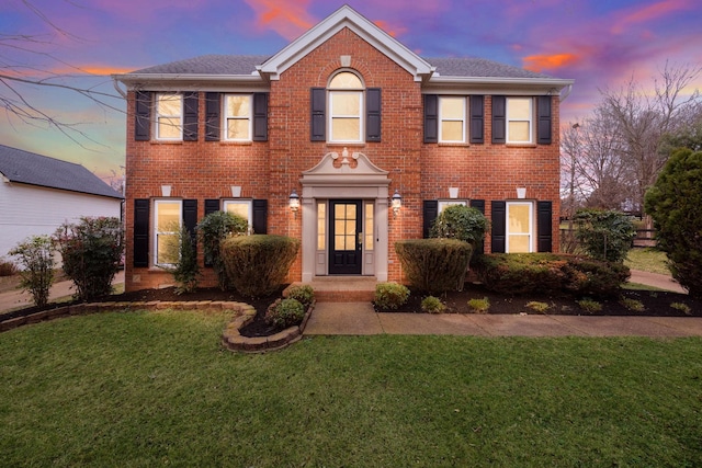 colonial-style house featuring a yard