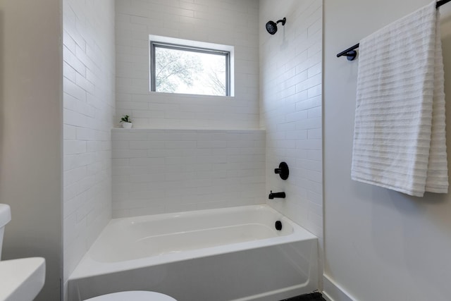 bathroom with tiled shower / bath and toilet