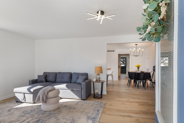 living room featuring an inviting chandelier and light wood-type flooring