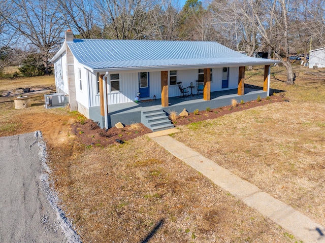 view of front of home with central AC unit, a front lawn, and covered porch