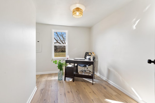 home office with electric panel and light wood-type flooring