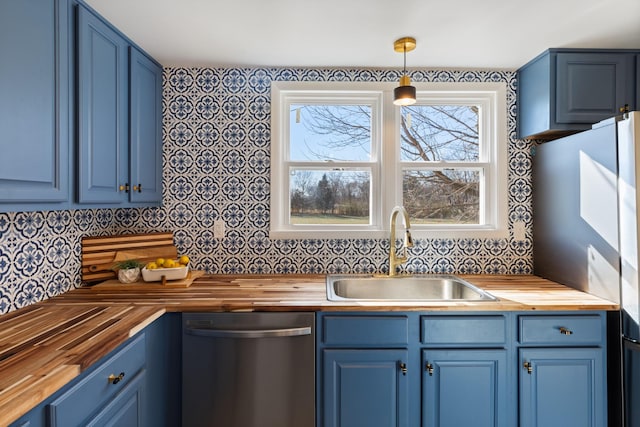 kitchen featuring hanging light fixtures, dishwasher, sink, and butcher block countertops