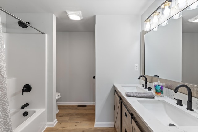 full bathroom featuring shower / washtub combination, hardwood / wood-style floors, vanity, and toilet