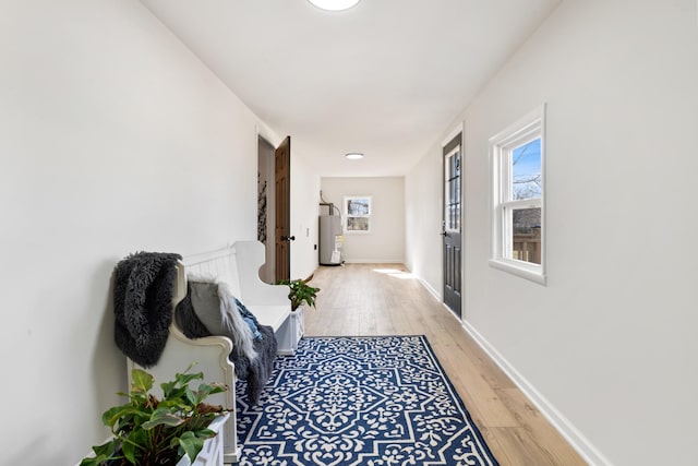 hallway with water heater and hardwood / wood-style floors