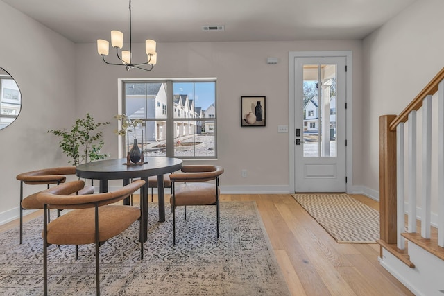 dining area featuring a notable chandelier and light hardwood / wood-style floors