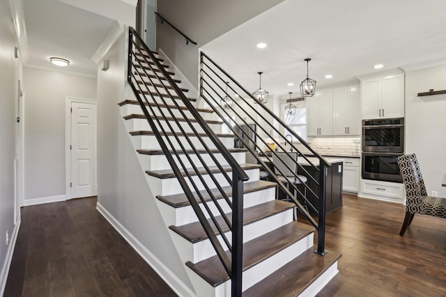 stairway with hardwood / wood-style floors and ornamental molding