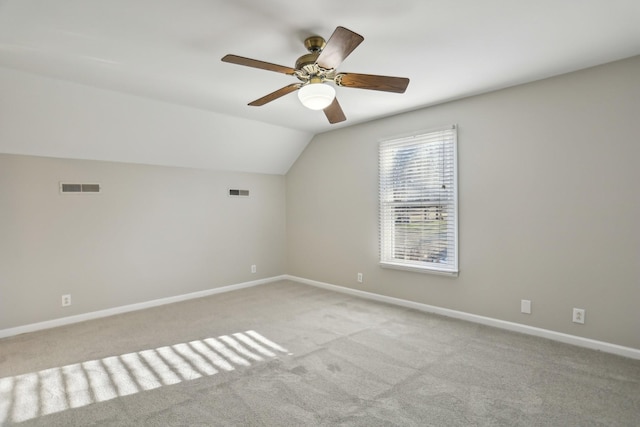 additional living space featuring ceiling fan, vaulted ceiling, and light carpet