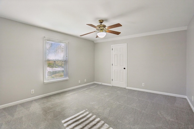 carpeted spare room featuring ceiling fan