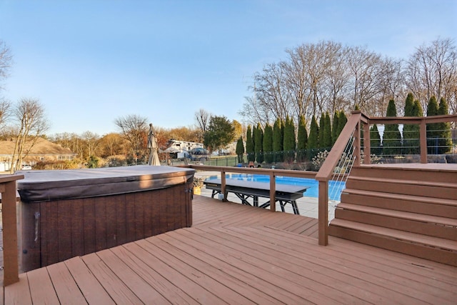 deck featuring a swimming pool with hot tub