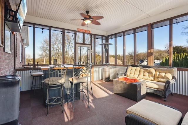 sunroom / solarium featuring ceiling fan