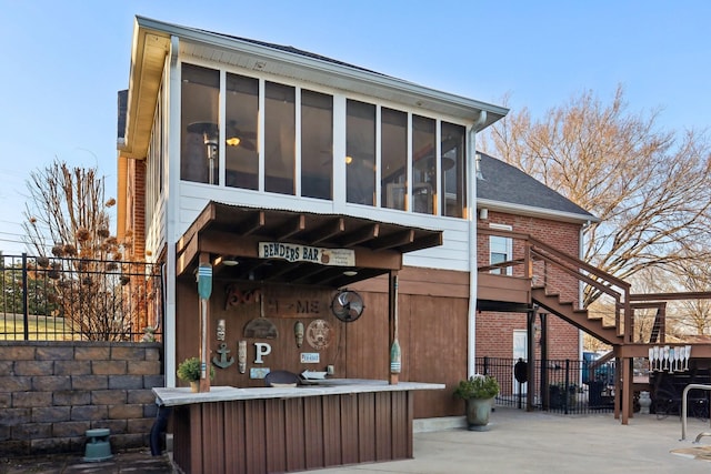 rear view of house with a patio area and a sunroom