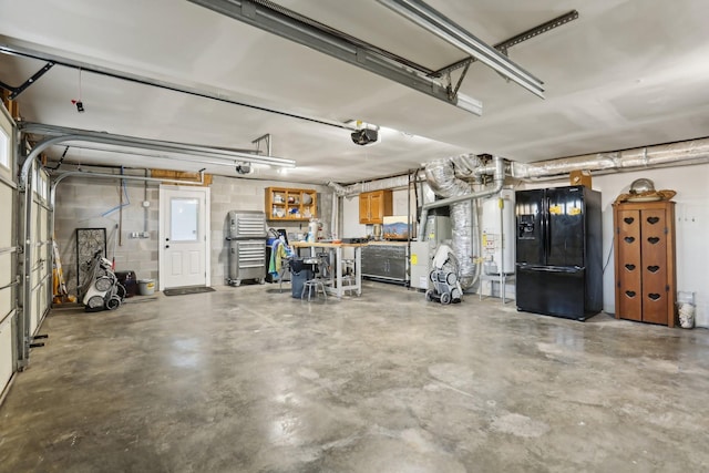 garage with a garage door opener, black refrigerator with ice dispenser, and water heater